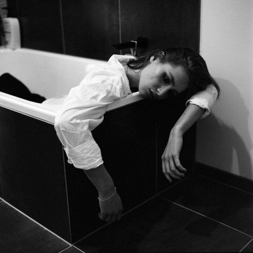 black and white portrait of a woman in a bath tub